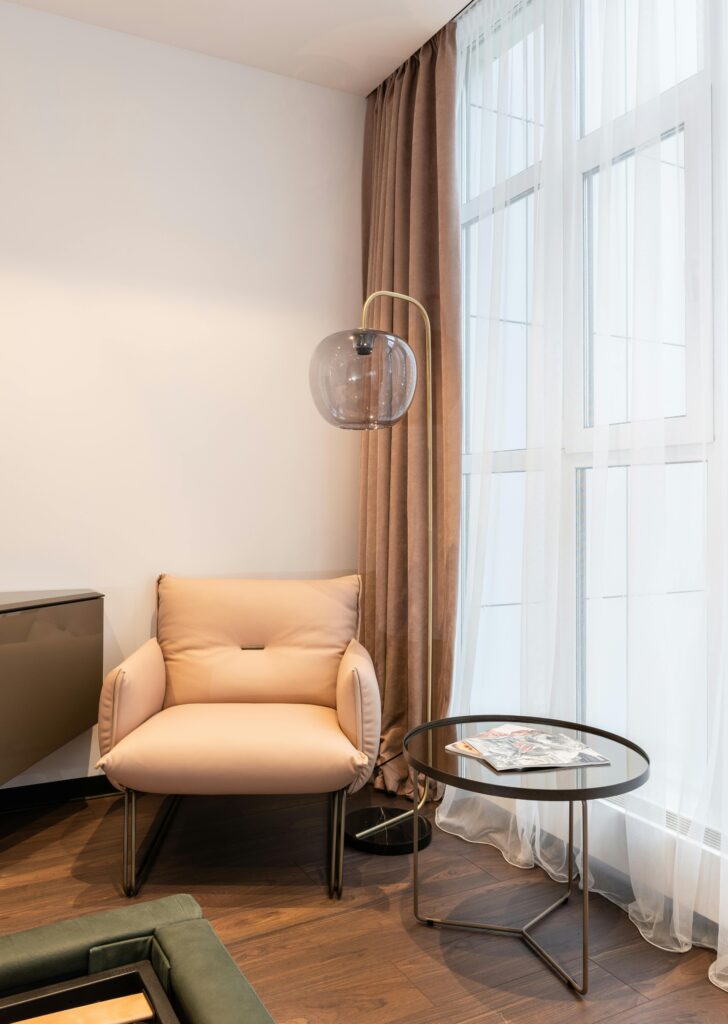 Neutral Living Room Ideas: 15 Warm and Layered Spaces neutral living room with floor-to-ceiling curtains and structured accent seating