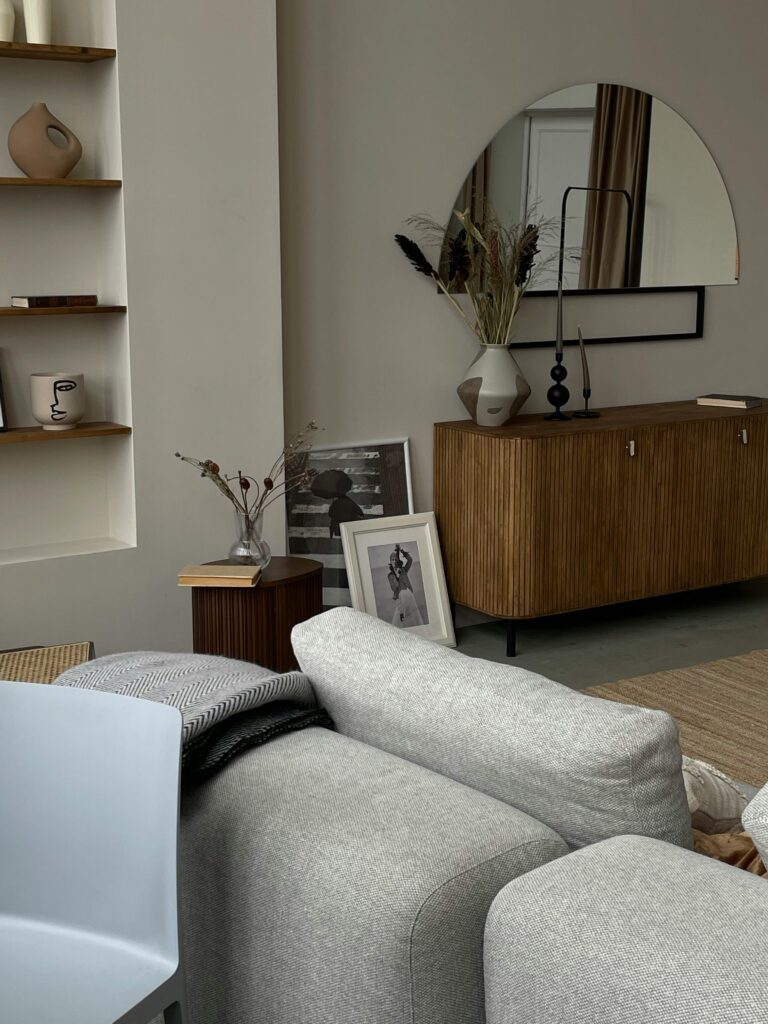 Neutral Living Room Ideas: 15 Warm and Layered Spaces neutral living room with console table and round mirror styling