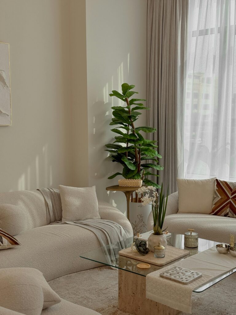 Neutral Living Room Ideas: 15 Warm and Layered Spaces sunlit neutral living room with indoor plant and soft filtered light