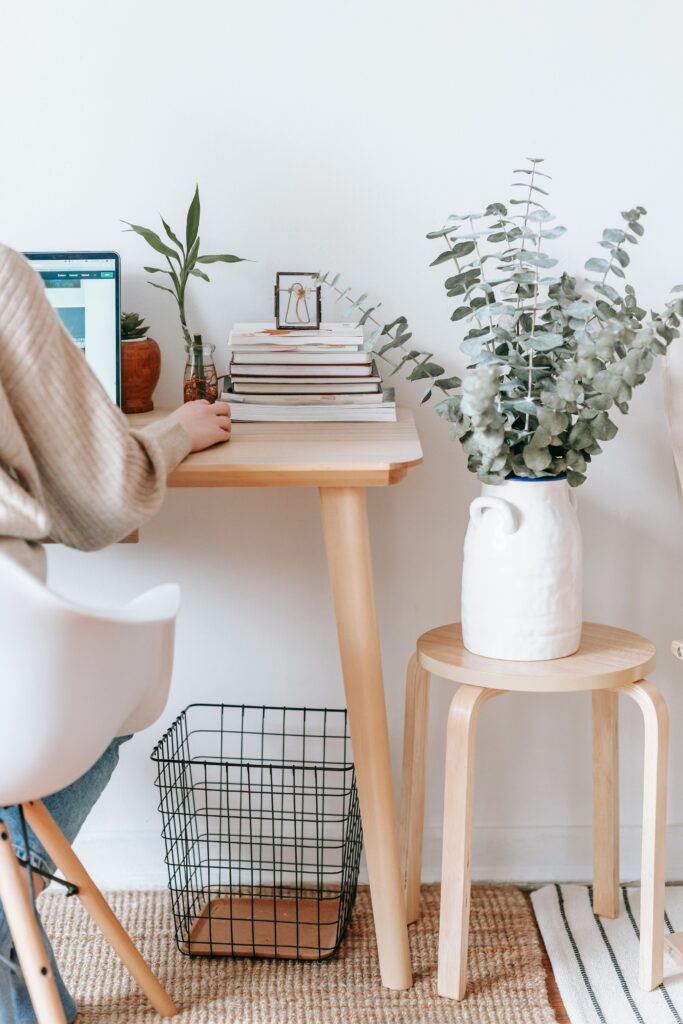 15 Neutral Office Decor Ideas That Feel Calm, Curated, and Intentional small neutral desk setup with layered books, greenery, and wire basket underneath